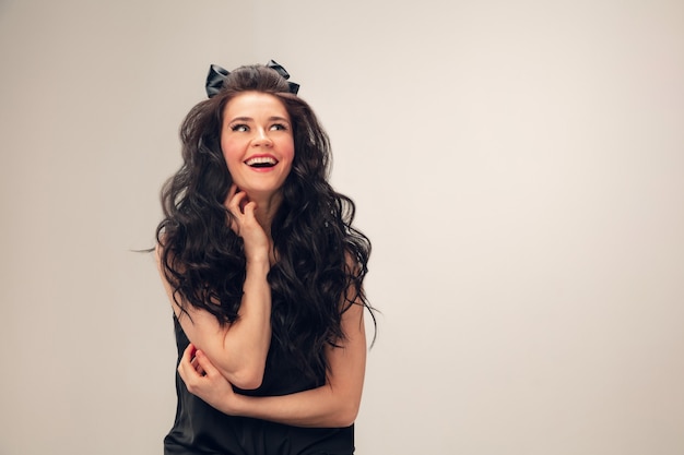 Portrait of beautiful young woman isolated on grey  wall