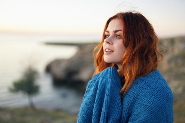 Foto ritratto di una bella giovane donna che guarda il mare durante il tramonto