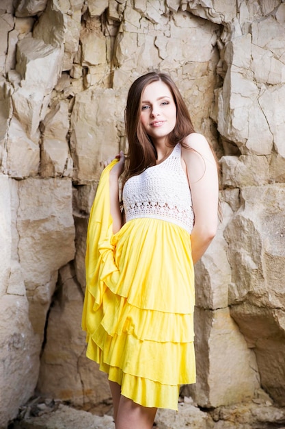 Ritratto di una giovane e bella donna sulla natura. ragazza in un vestito lavorato a maglia nelle rocce.