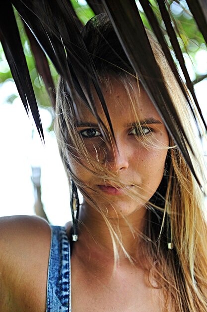 Portrait of beautiful young woman under palm tree