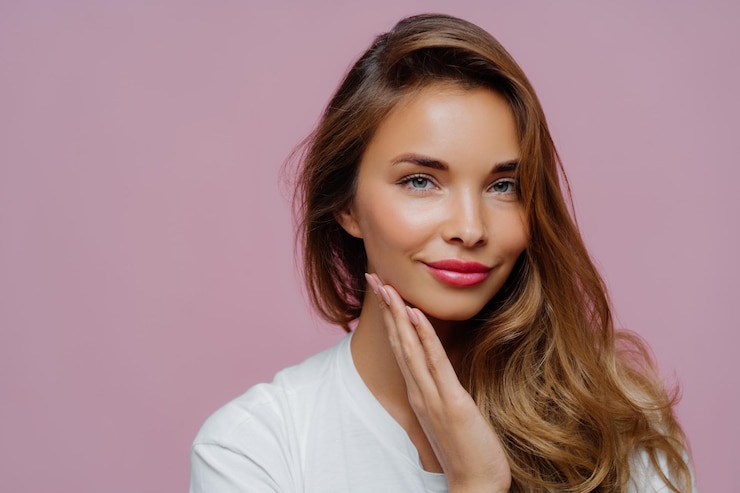 Photo portrait of beautiful young woman over pink background