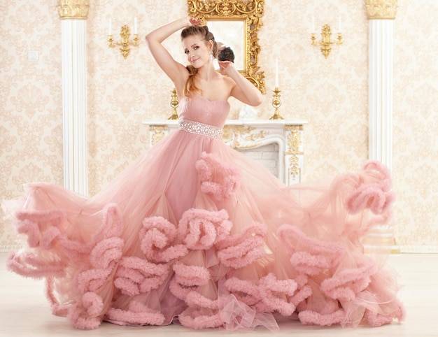 Photo portrait of beautiful young woman in pink dress