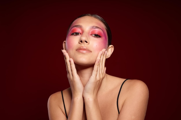 Portrait of beautiful young woman pink face makeup posing\
attractive look skin care cropped view unaltered