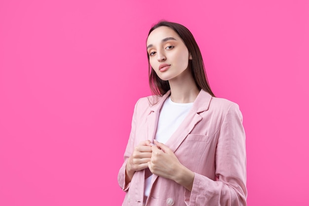 Portrait of beautiful young woman in pink jacket thinking isolated on red background