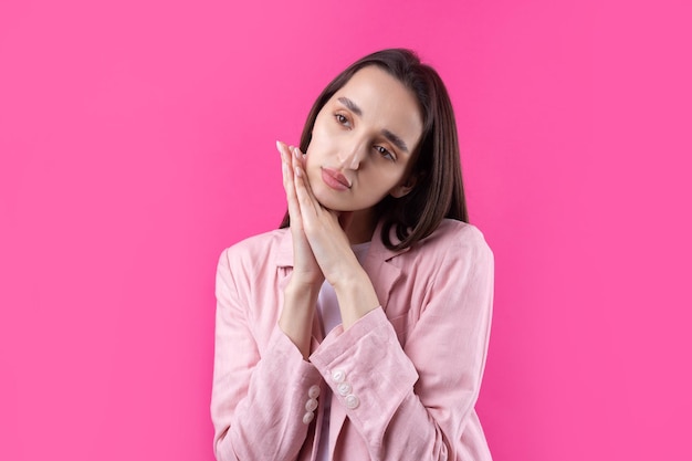 Portrait of beautiful young woman in pink jacket thinking isolated on red background