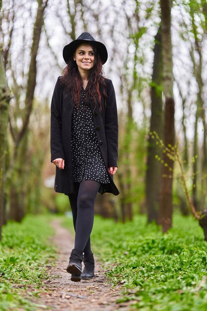 Portrait of a beautiful young woman in a rainy spring day in\
the park