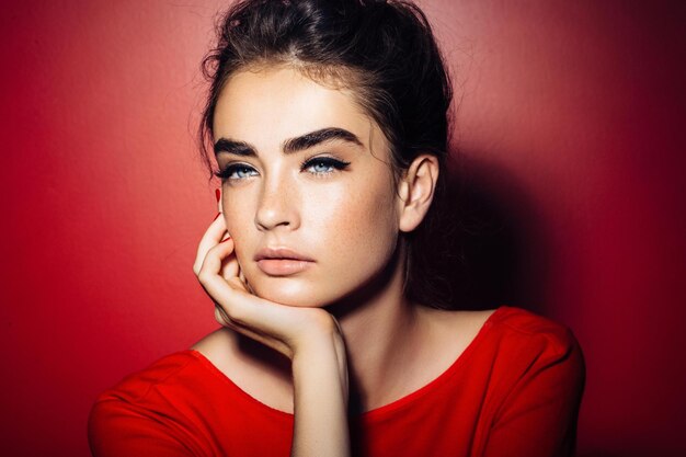 Portrait of beautiful young woman on red background