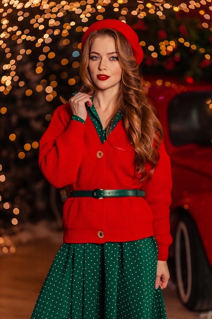 Portrait of a beautiful young woman in a red beret against the background of christmas lights