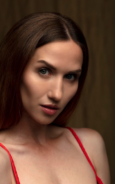 portrait of a beautiful young woman in a red dress studio shot on a dark background