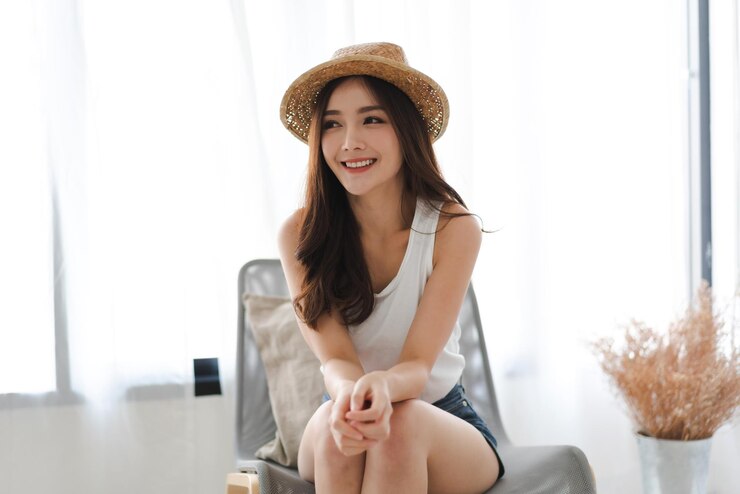 Photo 모자를 입고 앉아 있는 아름다운 젊은 여성의 초상화