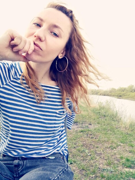 Photo portrait of beautiful young woman sitting on land