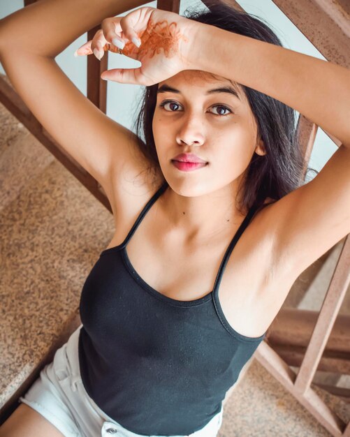 Photo portrait of beautiful young woman sitting on staircase