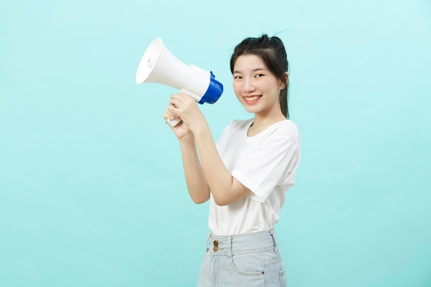 Portrait beautiful young woman smile with megaphone isolated over the blue background