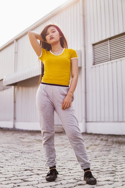 Portrait of beautiful young woman standing against built structure