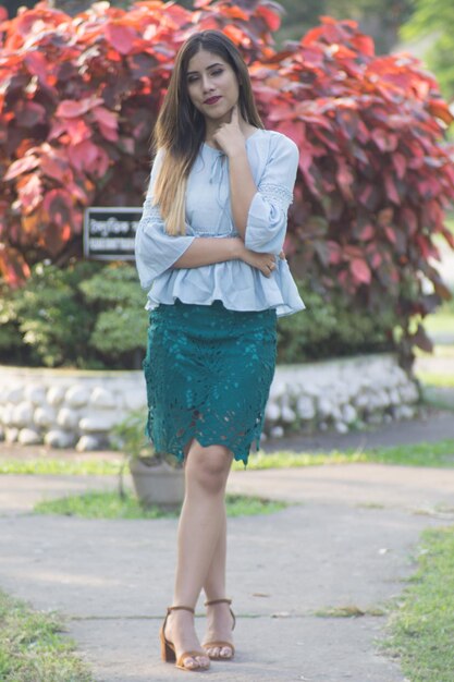 Photo portrait of beautiful young woman standing against flowering plants