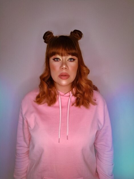 Photo portrait of beautiful young woman standing against pink background