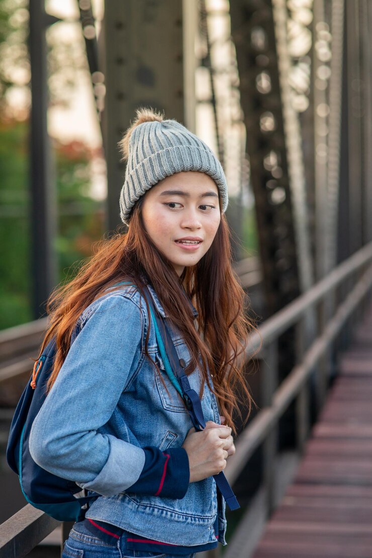 Photo レールに寄りかかって立っている美しい若い女性の肖像画