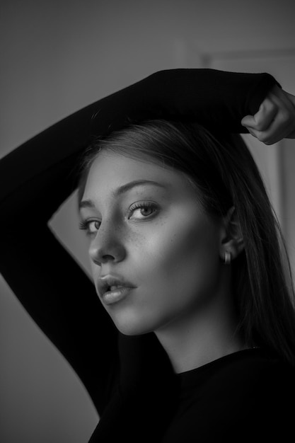 Portrait of beautiful young woman standing against wall at home