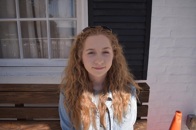 Photo portrait of beautiful young woman standing against wall