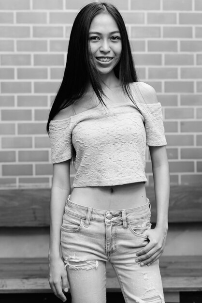 Portrait of beautiful young woman standing against wall