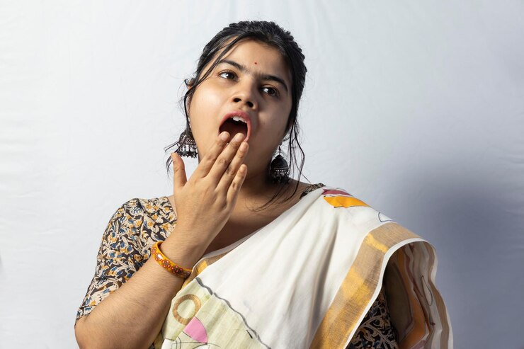 फोटो सफ़ेद बैकग्राउंड के सामने खड़ी खूबसूरत युवा महिला का पोर्ट्रेट।