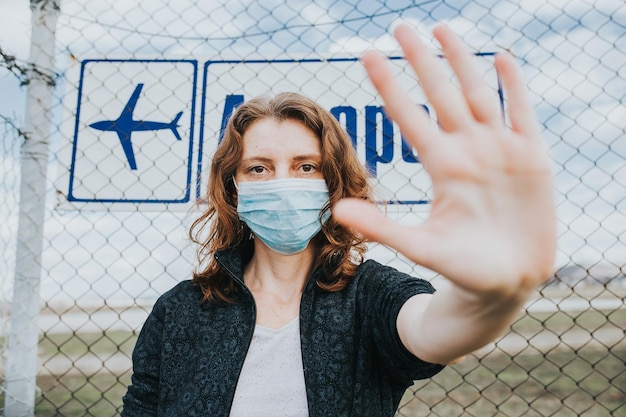 Photo portrait of beautiful young woman standing by chainlink fence