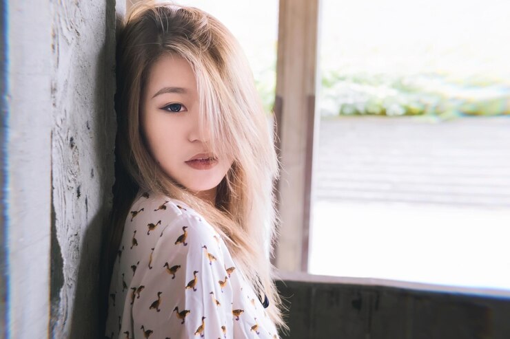 Photo 壁に立っている美しい若い女性の肖像画