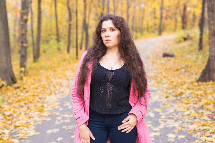 फोटो portrait of beautiful young woman standing in forest during autumn
