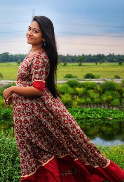 Portrait of beautiful young woman standing on land