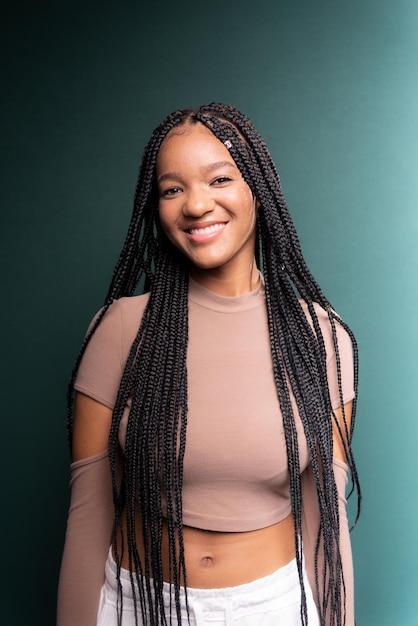 Premium Photo  Portrait of beautiful young woman standing with big braids  in her hair isolated on dark green background