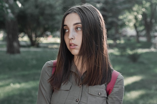 Portrait of a beautiful young woman in a summer park