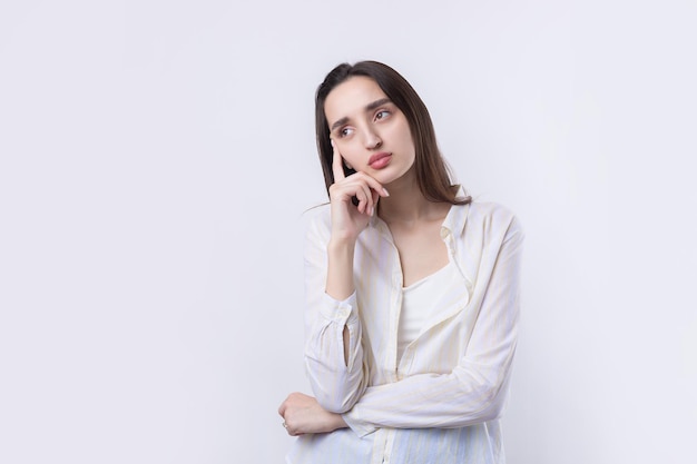 Portrait of a beautiful young woman thinking isolated on white background