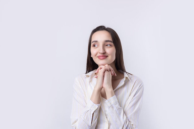 Ritratto di una bella giovane donna che pensa isolato su sfondo bianco