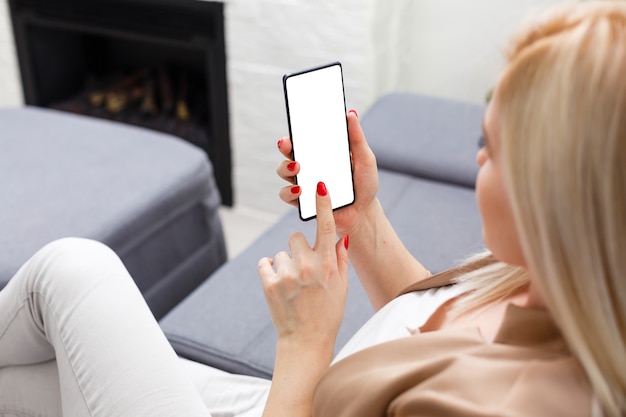 Portrait of beautiful young woman using her mobile phone at home.