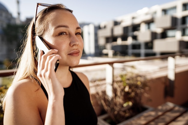 Portrait of beautiful young woman using smartphone on outdoor terrace in istanbul