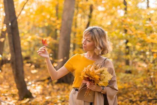 Portrait of beautiful young woman walking outdoors in autumn fall season and stylish girl concept