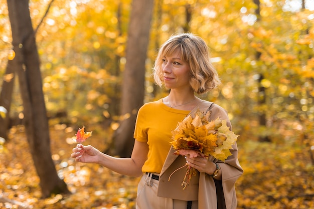 가을 시즌에 야외에서 산책하는 아름다운 젊은 여성의 초상화와 세련된 소녀 컨셉