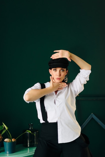 Portrait of a beautiful young woman in a white shirt and black trousers