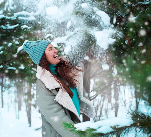 Портрет красивой молодой женщины в зимнем лесу со снегом