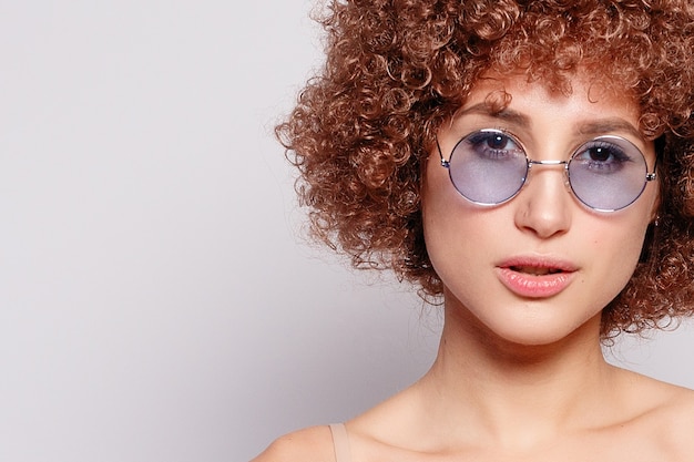 Portrait of a beautiful young woman with afro haircut and makeup