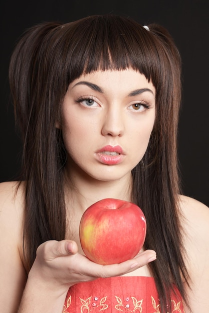 Portrait of beautiful young woman with apple