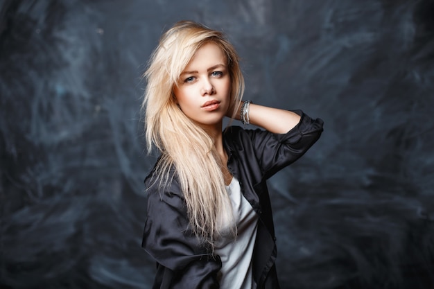 Portrait of a beautiful young woman with blond hair in a black shirt and a white shirt