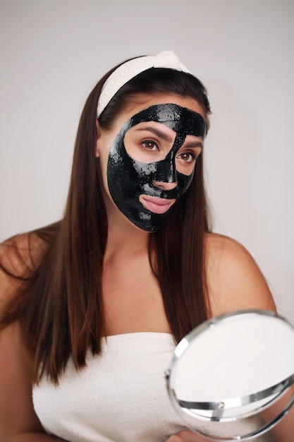 Portrait of a beautiful young woman with cleansing black mask