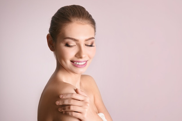 Photo portrait of beautiful young woman with clear skin on color background