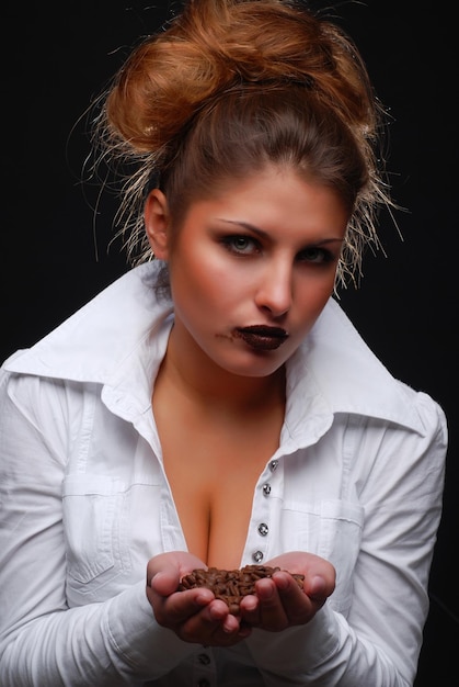 Portrait of beautiful young woman with coffee beans in her hands