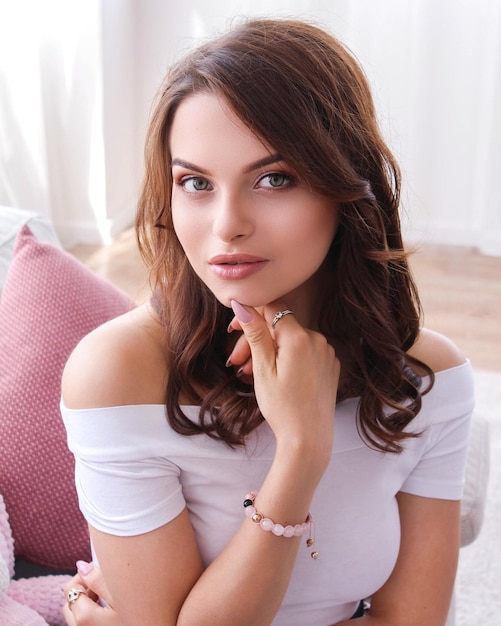 Portrait of beautiful young woman with hand on chin at home