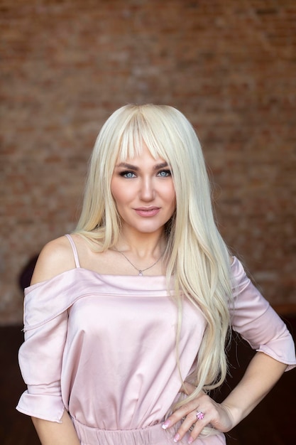 Portrait of beautiful young woman with long curly blonde hair