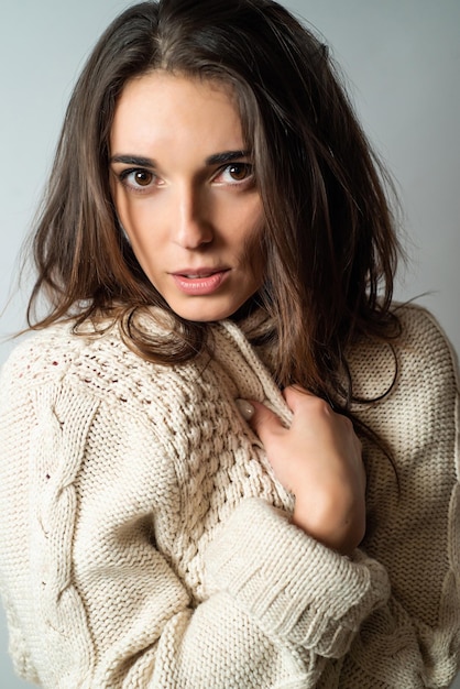 portrait of a beautiful young woman with long hair in a cozy sweater