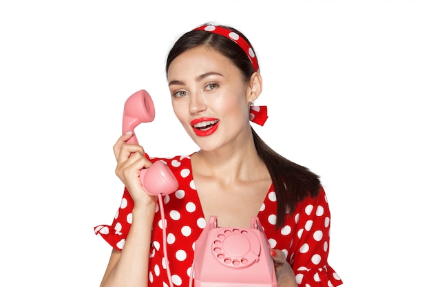 Portrait of beautiful young woman with phone, dressed in pin-up style.