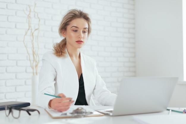 Portrait of beautiful young woman working in the office.